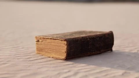 Old book on the sand beach Stock Illustration