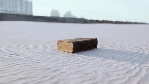 Old book on the sand beach Stock Illustration