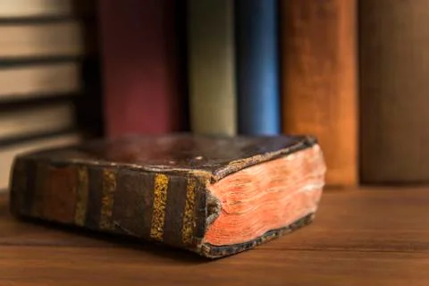 Old book with a stack of books in the background. Stock Photos