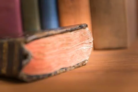 Old book with a stack of books in the background. Stock Photos