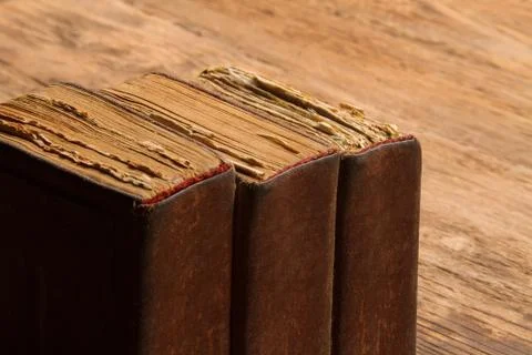 Old book stack, brown blank spine yellow pages, macro of weathered aged cover Stock Photos