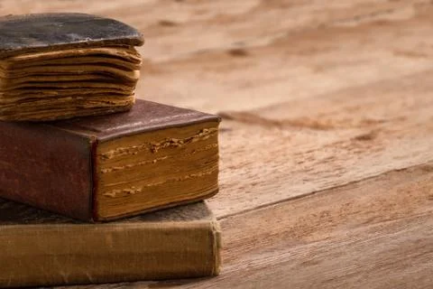 Old book stack, brown pages blank spine, macro of aged library heap on table Stock Photos