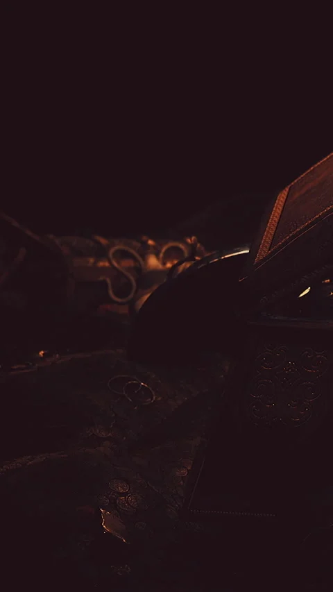 Old books and tools arranged on a dark wooden surface in a dim light Stock Footage 338424970