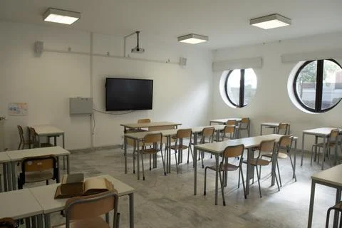 Old books on desk in empty classroom Stock Photos