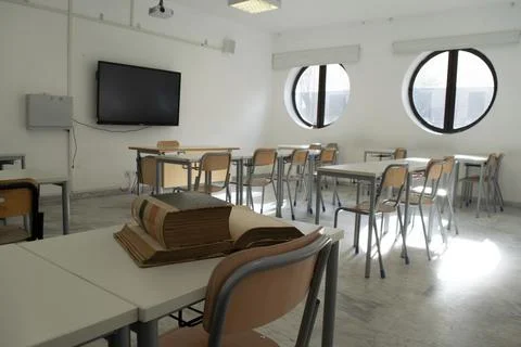 Old books on desk in empty classroom Stock Photos