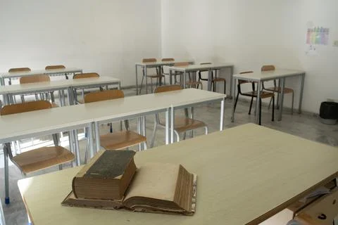 Old books on desk in empty classroom Stock Photos