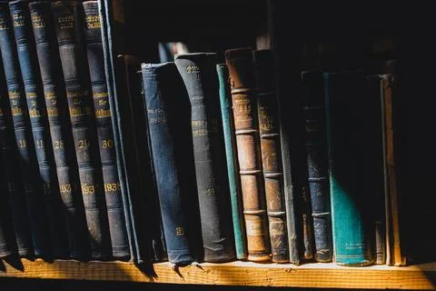 Old books on the shelf in the library under the sun ray Stock Photos