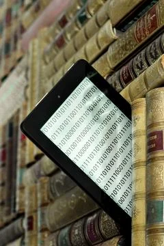 Old books on the shelf with a tablet in between Stock Photos