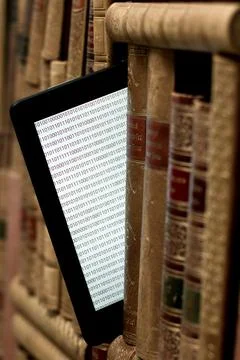 Old books on the shelf with a tablet in between Stock Photos