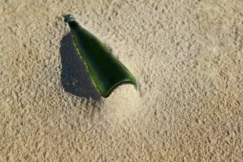 Old bottle on the beach Stock Photos