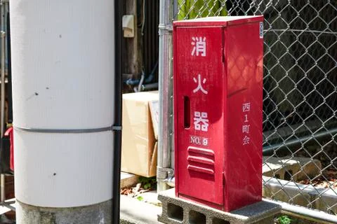 An old box of fire extinguishers on a small street Stock Photos