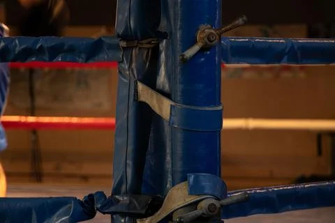 An old boxing ring with a worn corner post and ropes in a gym Stock Photos