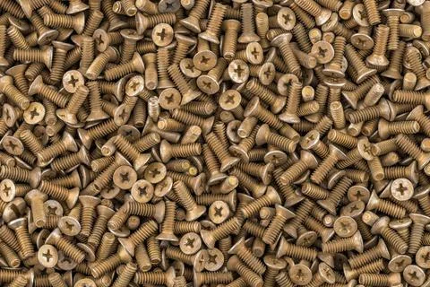 Old brass countersunk head screws with a phillips head screwdriver. Texture, Stock Photos