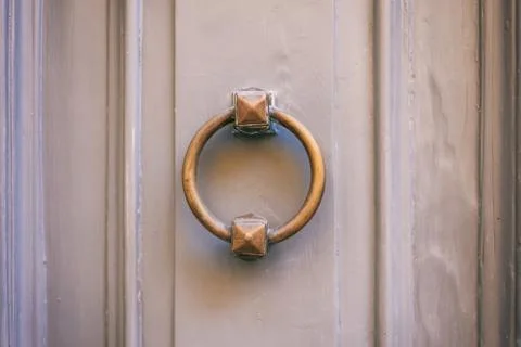 Old brass door knocker, ring shape, on a gray painted front door Stock Photos