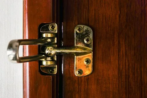 Old brass security latch swing door lock. Close Up of the vintage unlocked .. Stock Photos