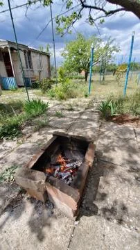 Old brazier made from red bricks with campfire flaming inside. Stock Photos