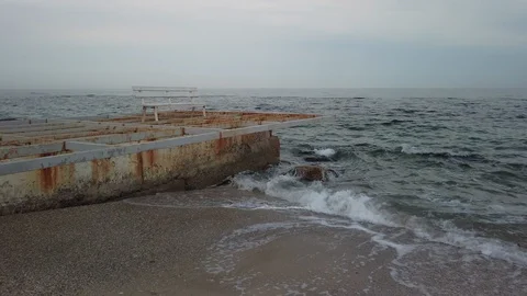Old breakwater and empty bench in the evening - Pan Stock Footage 108786066