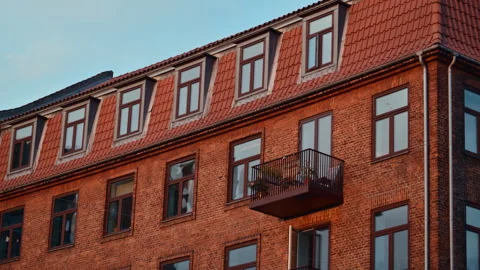 Old brick apartment building facade showcasing windows, balconies, and a tiled Stock Footage 325223858