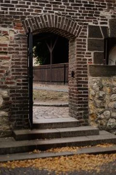 Old brick archway opening to tranquil courtyard in autumn in Vysehrad Prague Stock Photos