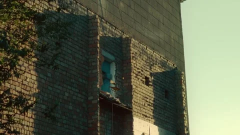 Old brick building facade with teal door and long shadow Stock Footage 341128995