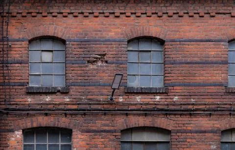 Old brick building facade with windows and wiring in an urban setting Stock Photos