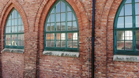 Old brick building with Gothic windows and gable roof, pedestal shot Stock Footage 134763529