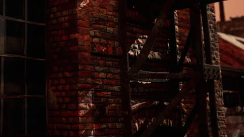 Old brick building at sunset with rusty metal structure nearby Stock Footage 337875271