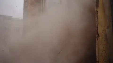 Old brick building undergoing demolition as exterior wall collapses, sending Stock Footage 327731397