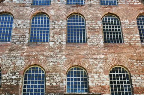 Old brick building with windows. A building with loose plaster. Stock Photos