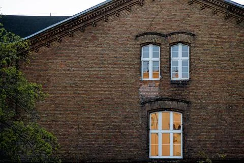 An old brick building with windows, seen from below. A fragment of the hist.. Stock Photos