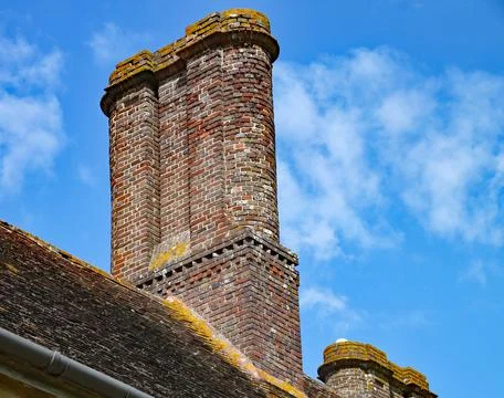 An old brick chimney stack atop an old English house Stock Photos