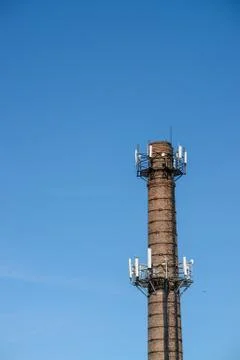 Old brick chimney turn into cellular tower. Stock Photos