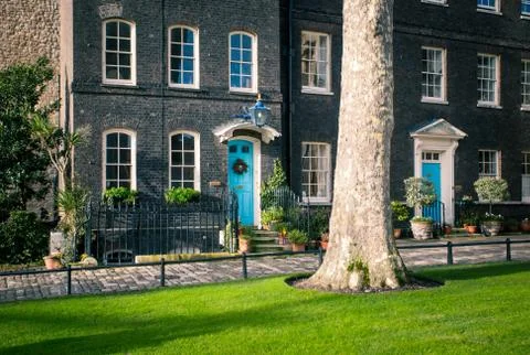 An old brick house with a plot of green grass and tree Stock Photos