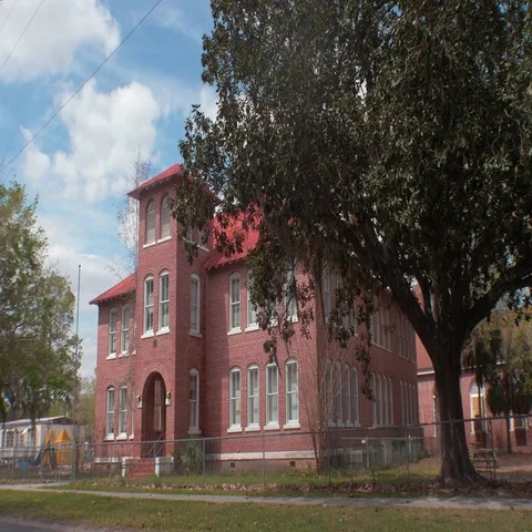 Old Brick School Building with Playground and School Buses, 4K Stock Footage 69525697