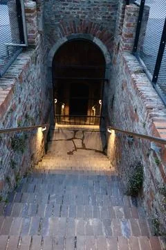 Old brick staircase leading down to an arched gate Stock Photos
