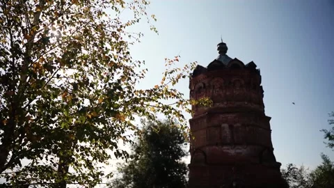 Old brick tower with sun behind autumn birch tree Vídeos de archivo 347535864