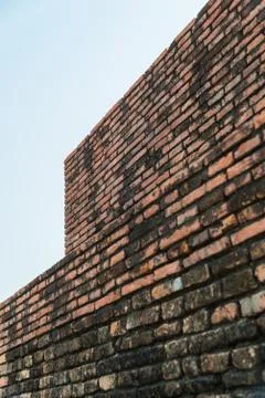 Old brick wall and cloudy sky with selective focus Stock Photos