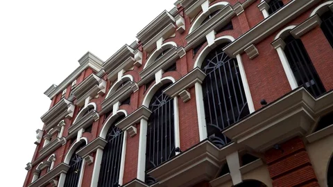 Old brick wall background building with vintage windows on bright cloudy sky Video stock 128742224