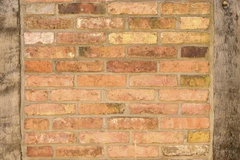 Old brick wall background texture with wooden uprights on either side Fotos de archivo
