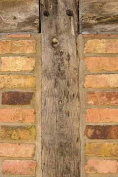 Old brick wall background texture with wooden uprights on either side Fotos de archivo
