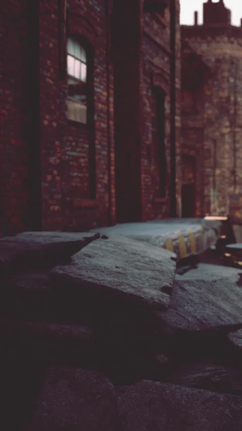 Old brick wall with broken pavement in an urban area at dusk Stock Footage 343155431