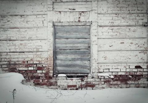 Old brick wall in the center of the window, laid nailed old boards Stock Photos