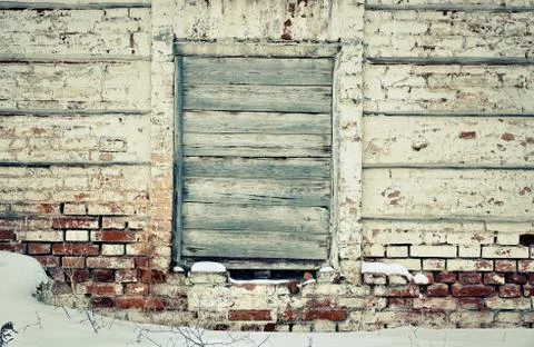 Old brick wall in the center of the window, laid nailed old boards 스톡 사진