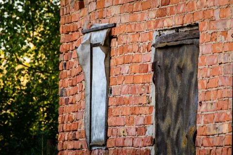 Old brick wall with closed window. Unstable and unsafe brick wall. Work safet Stock Photos