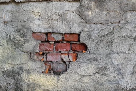 An old brick wall with gray plaster. Red brick. Stock Photos
