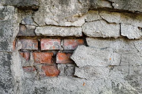 An old brick wall with gray plaster. Red brick. Stock Photos