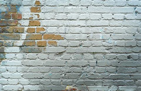 Old brick wall of grey blocks with wide cracks between them Stock Photos