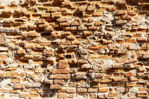 An old brick wall illuminated by sunlight. Stock Photos