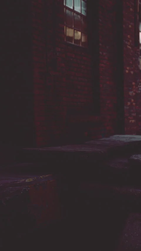 Old brick wall near steps at night with a window lit from inside Stock Footage 342655863