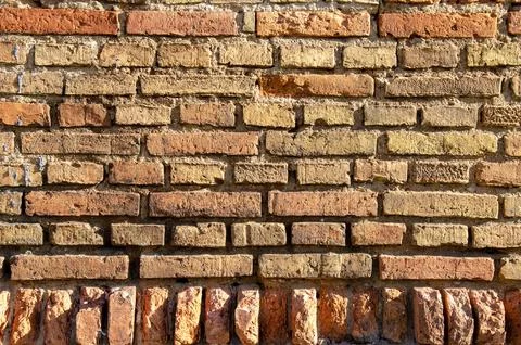 Old brick wall, old texture of red and orange blocks of stone. Closeup Stock Photos